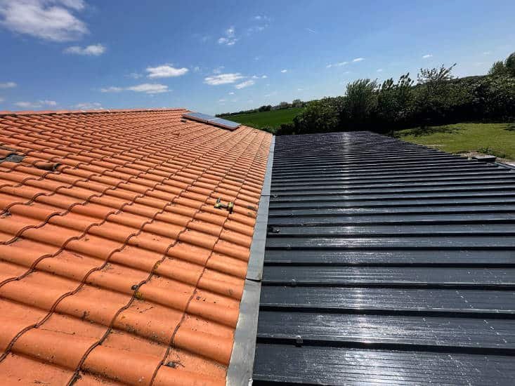 Vu sur une toiture en cours de rénovation, moitié tuiles, moitié bac, acier à Sainte en Charente-Maritime