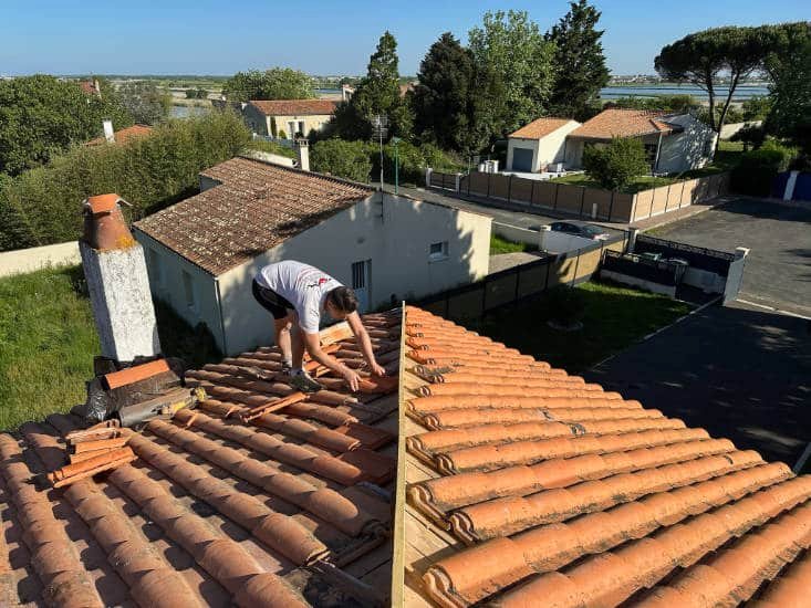 Rénovation de toiture en cours à échilais, M Argaillot Jersey entraiin de poser des tuiles