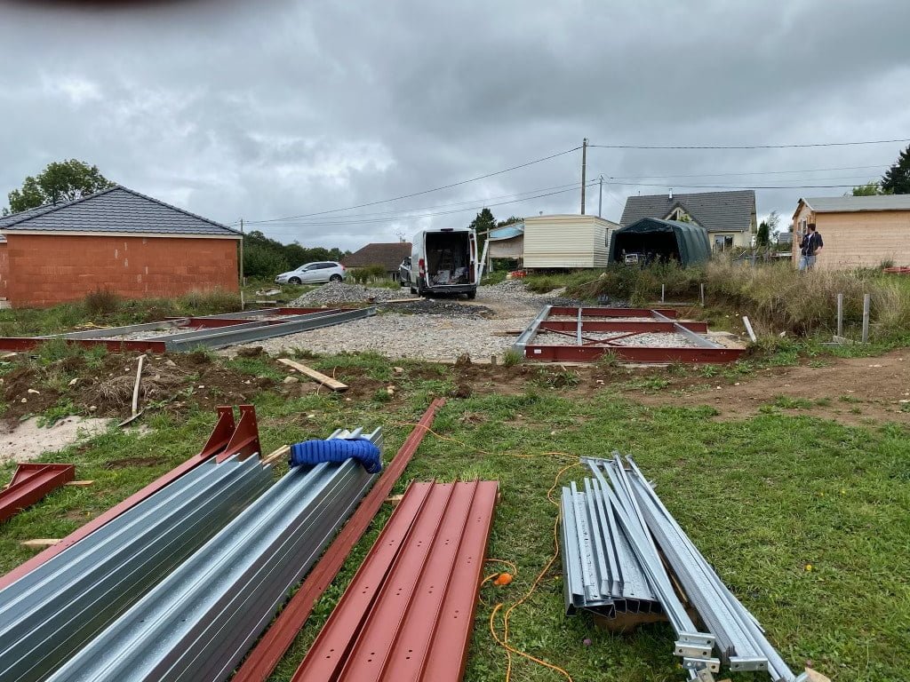 Vue sur des structures métalliques posée près d'un terrain préparé pour recevoir un hangar